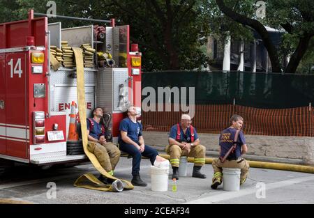 Austin, TX 8. Juni 2008: Müde Feuerwehrleute machen eine Pause, nachdem sie auf ein frühmorgendliches Feuer mit vier Alarmen reagiert haben, das das Landgut des Gouverneurs von Texas in der Innenstadt von Austin ausrottete. Mehr als 100 Feuerwehrleute kämpften um die Rettung der 152 Jahre alten Struktur. Das Gebäude wurde gerade renoviert und alle historischen und antiken Möbel waren im Lager. Beamte vermuten, dass das Feuer von einem Brandstifter ausgelöst wurde. ©Bob Daemmrich Stockfoto