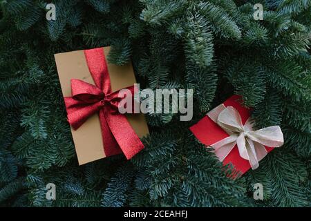 Von oben Aufnahme von zwei Weihnachtsgeschenkschachteln, die darauf liegen Grüne Zweige von Nadelbaum Stockfoto