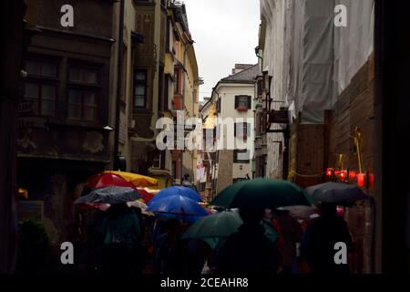Menschen mit Sonnenschirmen an einem regnerischen Tag in Innsbruck, Österreich. Stockfoto