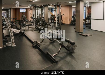 Verschiedene Trainingsgeräte stehen in geräumigen stilvollen Raum der modernen Fitnessraum Stockfoto