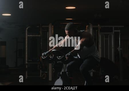 Serious schwarzen Mann auf Heimtrainer im Fitnessstudio Stockfoto