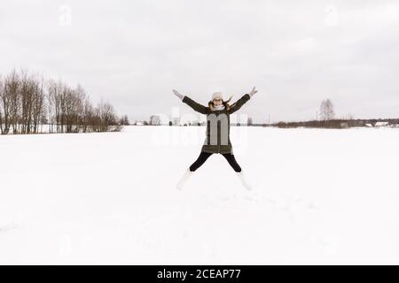 Junge Dame in Winter tragen Spaß im Schnee Wiese und bewölkter Himmel in Vilnius, Litauen Stockfoto