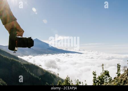 Erntegut hand der Fotografin stehen auf der Spitze des Hügels mit cloudscape sonnigen Tag Stockfoto