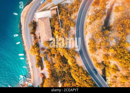 Luftaufnahme der Straße und Boote im Meer bei Sonnenuntergang im Herbst Stockfoto