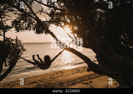 Rückansicht einer Frau, die sich ausruhte und Haare hielt, während sie am Meer in Thailand stand. Stockfoto