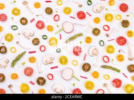 Verschiedene Gemüsesorten, Tomaten, Pilze, Spargel und Pfefferscheiben auf weißem Hintergrund gemischt Stockfoto