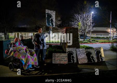 Sacramento, Kalifornien, USA. Februar 2020. Felicia Clark protestiert vor dem Kinderheim von Sacramento mit der Tochter Felicia Brent-Velasquez, 18, in Decken in ihrem Rollstuhl gehüllt, am Freitag, den 14. Februar 2020 in Sacramento. "Es ist schwer, die Dinge zu sehen, die ich dort draußen sehe, aber deshalb gehe ich immer wieder zurück. Ich möchte dort für einen Freitag herausstechen und nichts sehen. Ich möchte keine Kinder sehen. Ich möchte, dass die Menschen das tun, was sie tun sollen. Kinder gehen und gehen und Aktivitäten machen, Eltern kommen glücklich, eine Art von Prozess zu sein", sagte Clark. (Kredit I Stockfoto