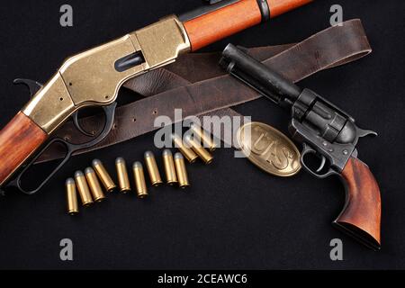 Altes Westgewehr mit Revolver und Munition auf schwarzer Leinwand Stockfoto