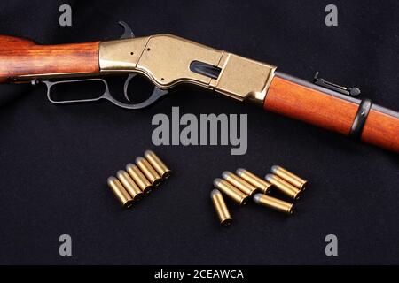 Altes Westgewehr mit Munition auf schwarzer Leinwand Stockfoto