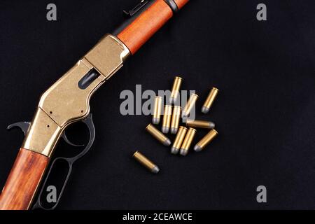 Altes Westgewehr mit Munition auf schwarzer Leinwand Stockfoto