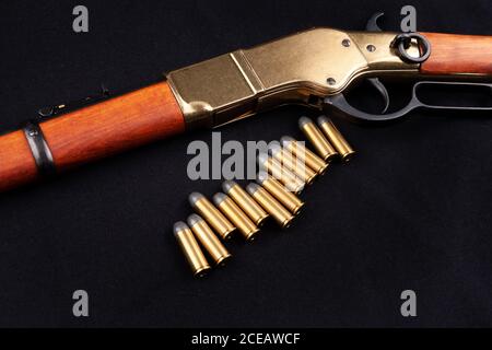 Altes Westgewehr mit Munition auf schwarzer Leinwand Stockfoto