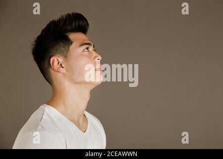 Junger Mann sitzt auf einem Stuhl im Studio Stockfoto