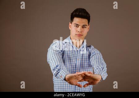 Lächelnder Mann, der auf grauem Hintergrund steht Stockfoto