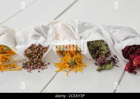 Filter Teebeutel gefüllt mit trockenen Heilkräutern - Majoran, Heidekraut, Ringelblumen und Rosenblüten. Alternative Medizin. Stockfoto
