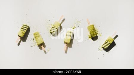 Flaches Lay von hausgemachten grünen Matcha Kokosnussbohnenzapfen mit Teepulver Stockfoto