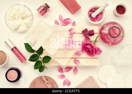 Basis für die Herstellung von Seife, Glas mit hausgemachten feuchtigkeitsspendenden Creme, Rosenblüte, infundiertes Wasser oder ätherische Ölflasche, Kokosöl, Rosenmischung oder aromatisierte wa Stockfoto