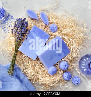 Hausgemachte Lavendel Seifenstücke und Süßigkeiten geformte Seife, Lavendelextrakt Flasche und trockene Lavendelblüten. Flach liegend. Stockfoto