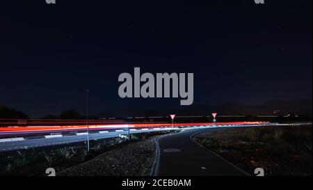 Lange Belichtung Aufnahme von hellen Spuren von Licht auf schöne Autobahn in der Nacht. Stockfoto