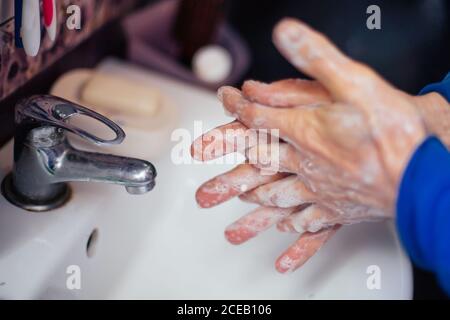 Älterer Mann wäscht die Hände mit Seife. Schutz vor Viren und Bakterien-Infektion. Desinfektion der Hände mit Wasser. Covid-19, Coronavirus pandemi Stockfoto