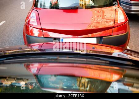 Perspektivische Ansicht der geparkten Autos in Reihe am Straßenrand von Stadtstraße bei Tageslicht Stockfoto