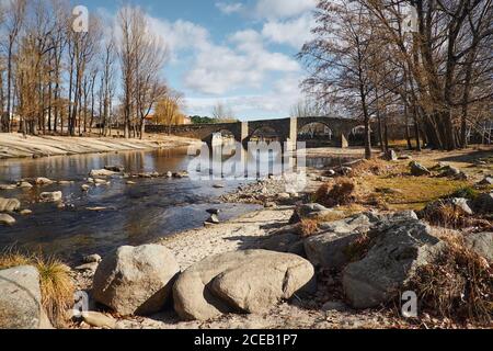 Brücke über ruhigen blauen Fluss Stockfoto