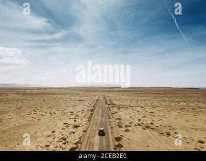 Luftaufnahme von leeren Wüste Land mit dem Auto fahren auf der Fahrbahn unter blauem Himmel, Spanien Stockfoto