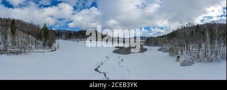 Idyllischer Winterbach auf einer Wiese zwischen einem Wald mit viel Schnee, wunderbares weißes Saisonfoto. Stockfoto