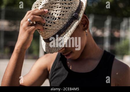 Afro Junge posiert mit Strohhut auf dem Basketball gericht seiner Nachbarschaft Stockfoto