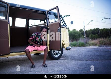 Schöne afro Mann genießt die Reise in ihrem vintage van Mit ein paar Freunden Stockfoto