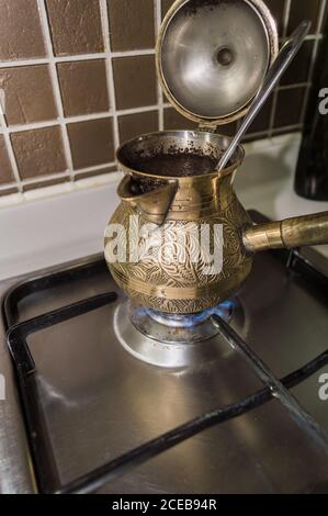 Brauen von frischem Kaffee in Bronze türkischen CEZVA auf Gasherd Am Morgen Stockfoto