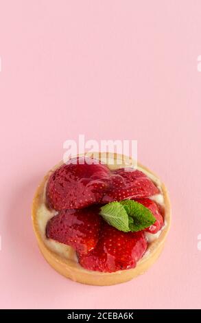 Nahaufnahme von köstlichen Dessert gefüllt mit Sahne und glasierte glänzende Erdbeere auf rosa Hintergrund. Stockfoto