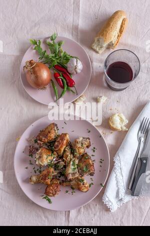 Gebratenes Huhn sind rote, grüne und Zwiebel Chilischoten. Auf rosa Hintergrund. Vorne oben. Flach liegend. Stockfoto