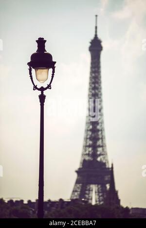 Brennende Laterne auf dem Hintergrund des hellblauen Himmels und des Eiffelturms Turm in Paris Stockfoto