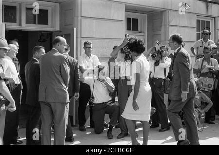 Vivian Malone, eine der ersten Afroamerikaner, die an der Universität von Alabama teilnahmen, geht durch eine Menschenmenge, die Fotografen, Mitglieder der Nationalgarde und den stellvertretenden US-Generalstaatsanwalt Nicholas Katzenbach umfasst, um das Foster Auditorium zu betreten, um sich für den Unterricht am 11. Juni 1963 anzumelden. Stockfoto