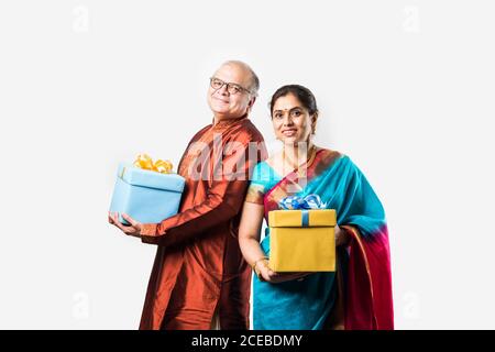 Porträt von glücklich indischen asiatischen Senior oder Rentner Paar mit Geschenkboxen, isoliert auf weißem Hintergrund Stockfoto