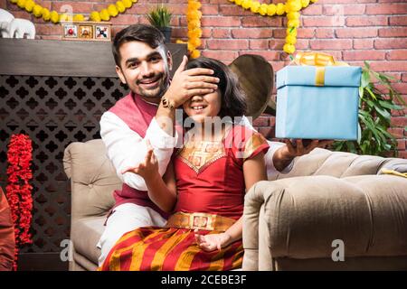 Happy niedlichen kleinen indischen Mädchen feiern Rakshabandhan oder Rakhi Festival Mit großem Bruder Stockfoto