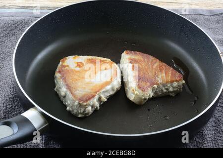 Kochen frische Ahi Thunfisch Filet Steaks mit Olivenöl in Bratpfanne Stockfoto