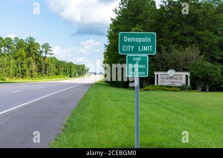 Demopolis, AL / USA- 30. August 2020: Demopolis City Limit Road sign mit dem Demopolis Welcome sign im Hintergrund, entlang der Autobahn 80. Stockfoto