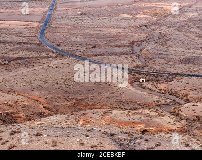 Herrliche Drohne Blick auf Asphaltstraße und gewundenen Fluss durch wunderbare trockene Tal auf Fuerteventura, Spanien Stockfoto
