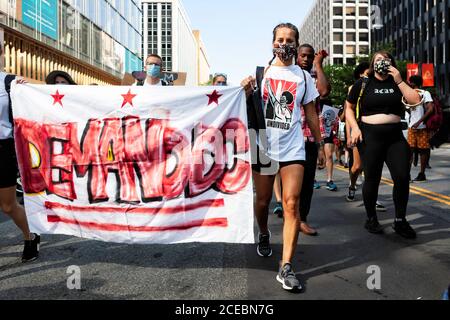 Washington, DC, USA, 28. August 2020. Im Bild: Demonstranten des Palm Collective tragen ihr DC-Banner an der Spitze eines protestmarsches. Loca Stockfoto