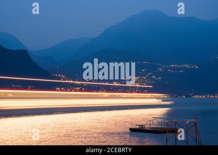 Motion Speed Licht der vorbeifahrenden Fähre auf Como See. Italien. Bunte Lichtspuren mit Bewegungsunschärfe-Effekt. Langzeitbelichtung. Stockfoto