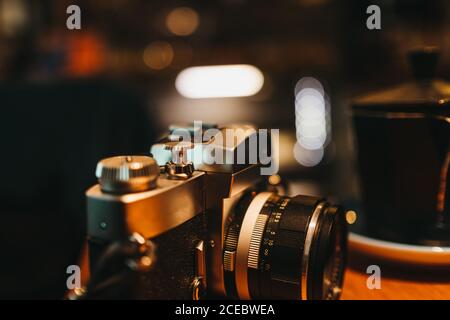Retro-Fotokamera auf Holztisch im stilvollen Café liegend Stockfoto