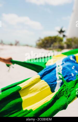 Tuch mit Flagge von Brasilien winken auf verschwommenem Hintergrund Strand in der Stadt Miami Stockfoto