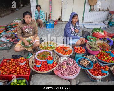 Sulawesi Island, Indonesien - August, 15 2015: Von oben Ethnische Weibchen sitzen auf dem Bürgersteig und verkaufen verschiedene reife Gemüse auf der Stadtstraße Stockfoto