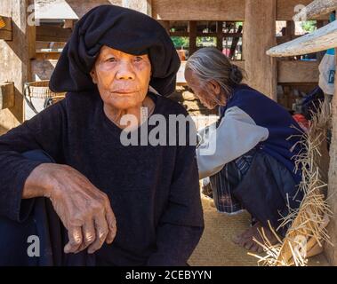 Sulawesi Island, Indonesien - August 15 2015: Ältere ethnische Weibchen sitzen in Holzscheune an sonnigen Tagen in einem kleinen Dorf Stockfoto