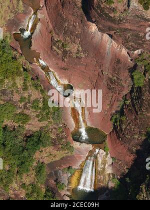 LUFTAUFNAHME. Mehrstufiger Wasserfall mit Tauchbecken in einer Landschaft aus roten Peliten. Vallon de Challandre, Beuil, Alpes-Maritimes, Frankreich. Stockfoto