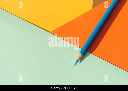 Farbstift, auf hellblauem und orangefarbenem geometrischen Hintergrund, zurück zum Schulkonzept Stockfoto