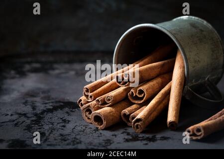 Zimtstangen in einem Vintage Blechbehälter auf dunklem Shabby Unbetonten Hintergrund Stockfoto