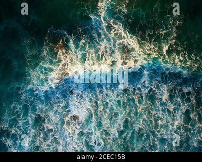 Drone Blick von oben auf die stürzenden türkisfarbenen Wellen mit weißem Schaum im Sonnenlicht, Chile Stockfoto