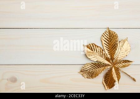 Designelemente ein goldenes Kastanienblatt auf weißen Brettern. Stockfoto